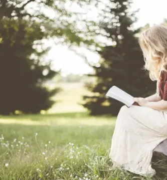 Mulher encontrando propósito através da leitura de livro cristão sobre espiritualidade feminina ao ar livre
